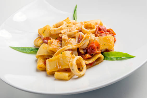 Dish Of Calamarata Pasta With Squid And Tomato On White Background